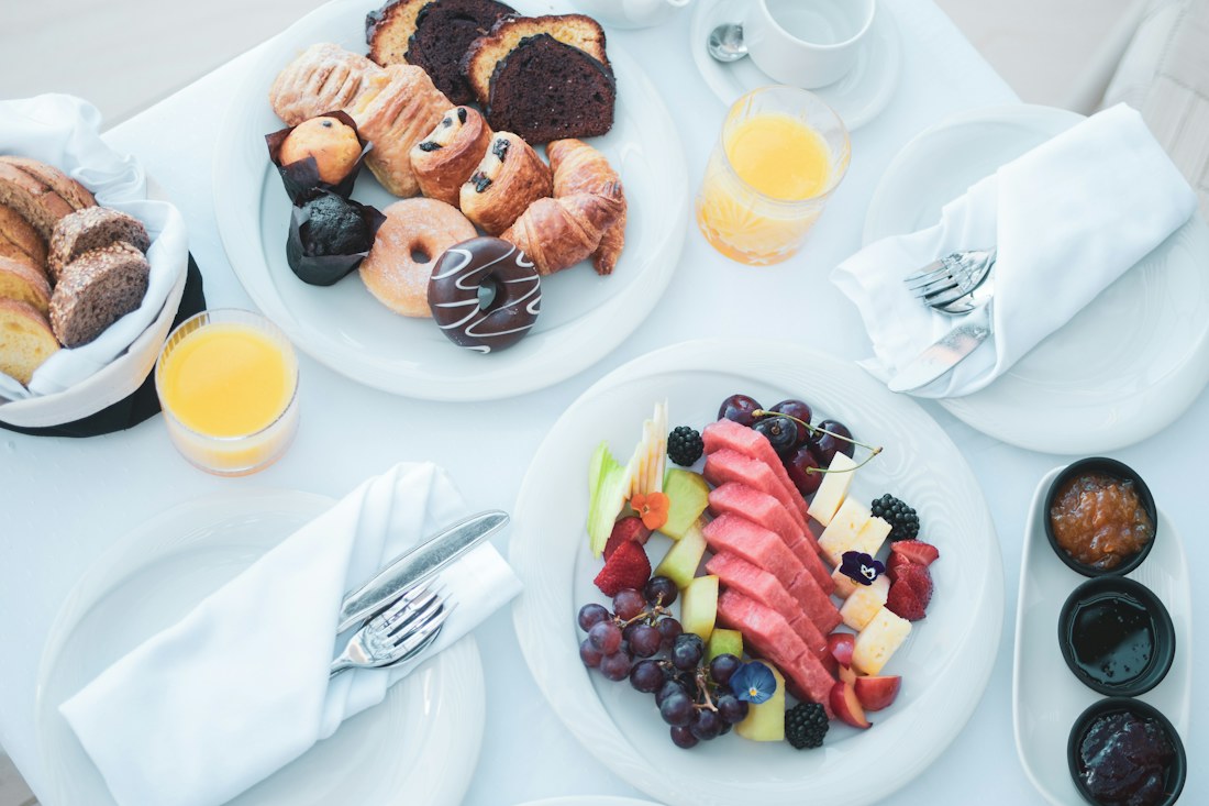 A carefully laid hotel breakfast with fruit and pastries