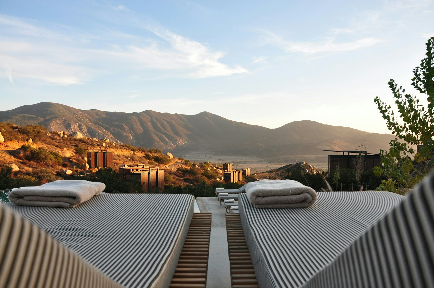 Sunset over a mountain valley from a hotel's poolside loungers